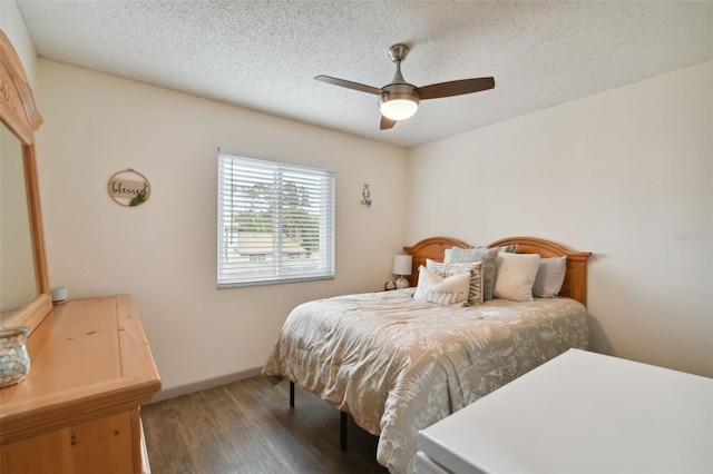 bedroom featuring a textured ceiling, ceiling fan, and dark hardwood / wood-style floors