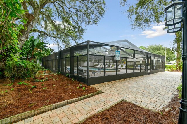 exterior space with a fenced in pool, a patio area, and a lanai