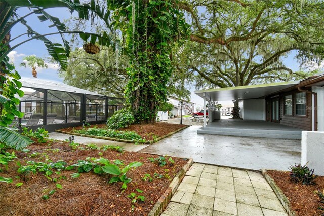 view of yard featuring a carport and a lanai