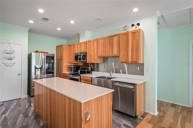 kitchen with sink, stainless steel appliances, dark hardwood / wood-style flooring, a kitchen island, and ornamental molding