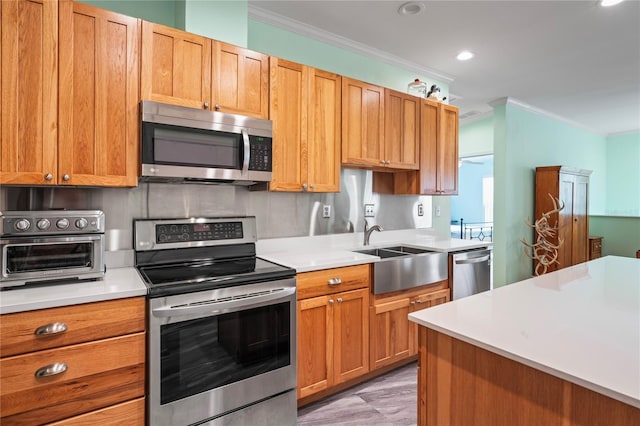 kitchen featuring stainless steel appliances, ornamental molding, and sink