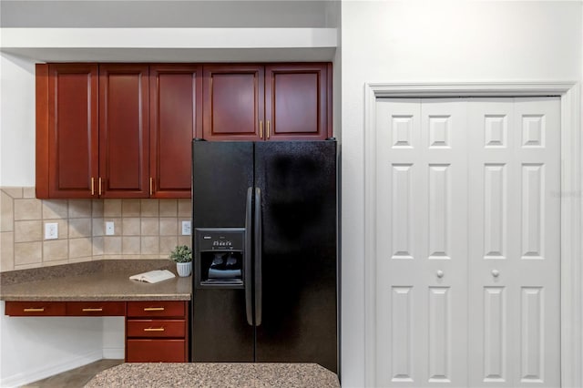 kitchen with black fridge, stone counters, and tasteful backsplash