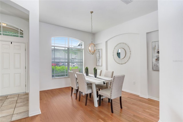 dining room with hardwood / wood-style floors and an inviting chandelier