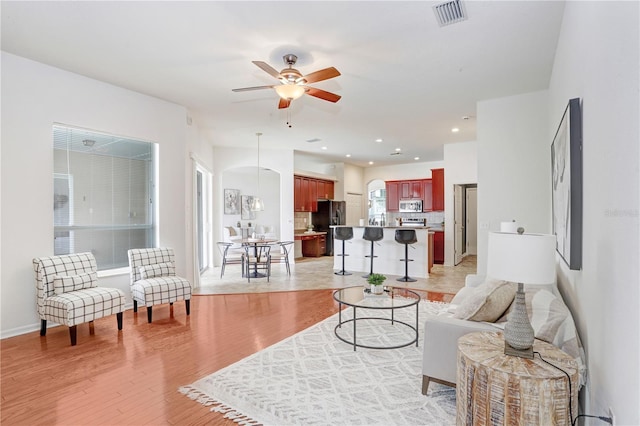 living room featuring ceiling fan and light wood-type flooring