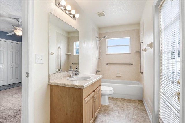 full bathroom featuring vanity, a textured ceiling, ceiling fan, toilet, and tiled shower / bath