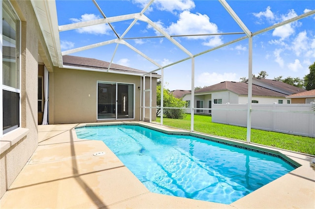 view of swimming pool with a yard, a patio area, and a lanai