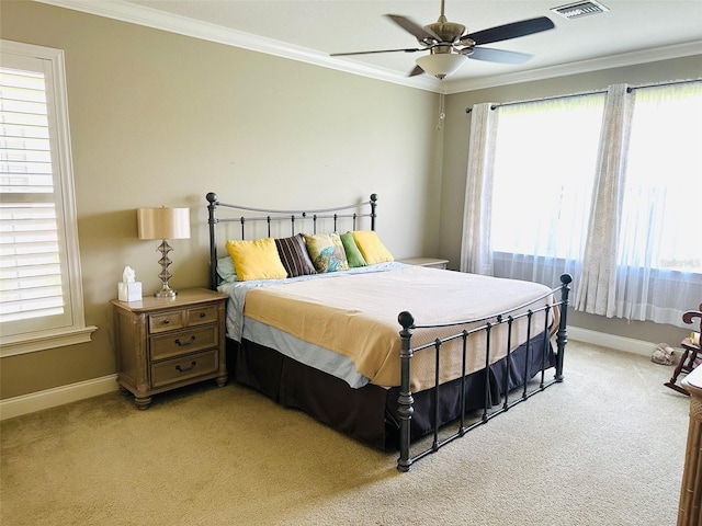 carpeted bedroom with ceiling fan and ornamental molding