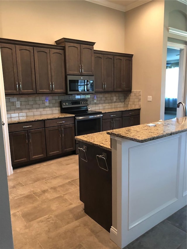kitchen featuring ornamental molding, electric range, decorative backsplash, dark brown cabinetry, and stainless steel microwave