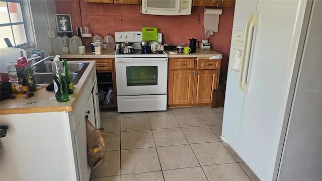 kitchen featuring light tile patterned flooring, sink, and white appliances