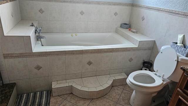 bathroom featuring tiled bath, toilet, tile walls, tile patterned floors, and vanity