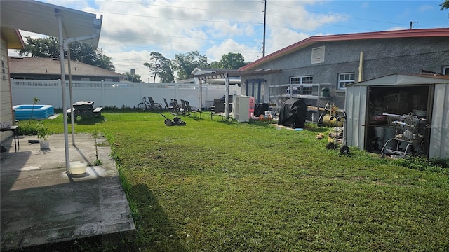 view of yard with a storage shed, a pergola, and a patio