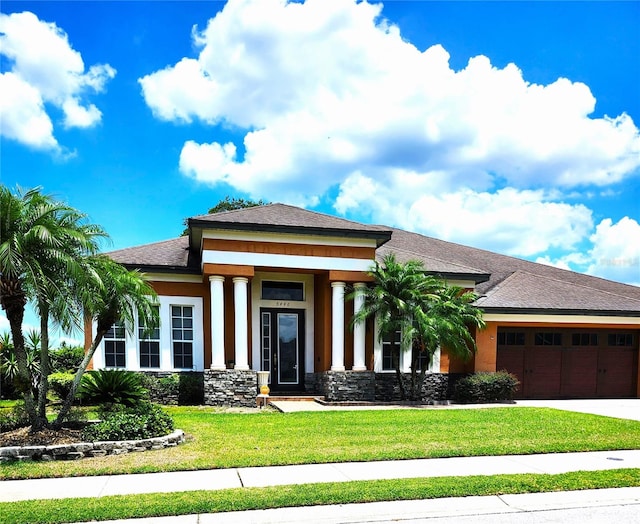 prairie-style home featuring a front yard and a garage