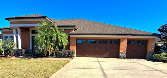 prairie-style house featuring a garage and a front yard