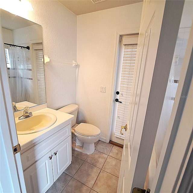 bathroom featuring tile patterned flooring, vanity, and toilet