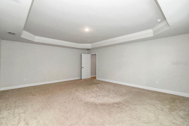 carpeted empty room with a tray ceiling and crown molding