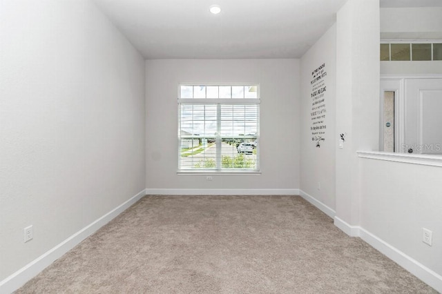 unfurnished room featuring light carpet