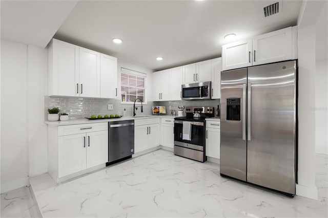 kitchen with backsplash, sink, white cabinetry, and stainless steel appliances