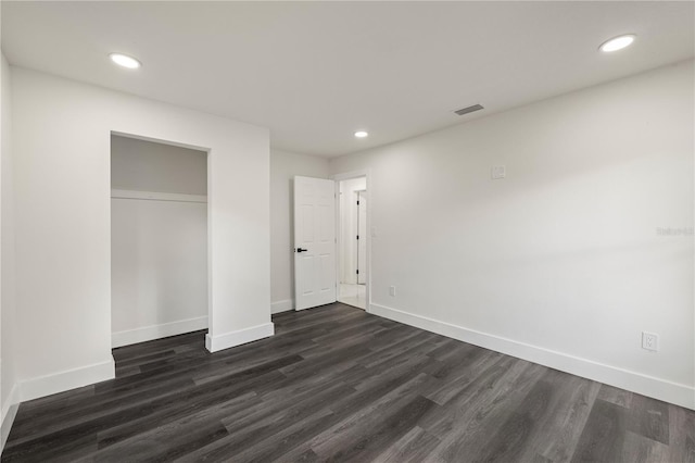 unfurnished bedroom featuring dark wood-type flooring and a closet