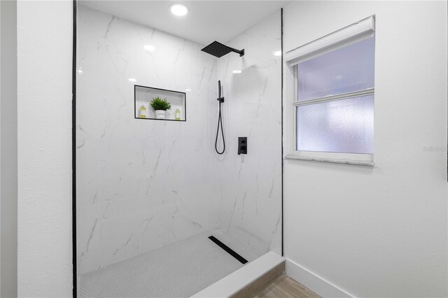 bathroom featuring tiled shower and hardwood / wood-style flooring