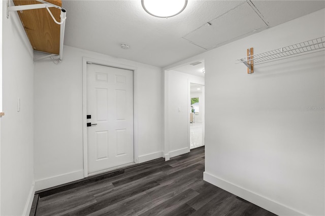 interior space with dark wood-type flooring and a textured ceiling