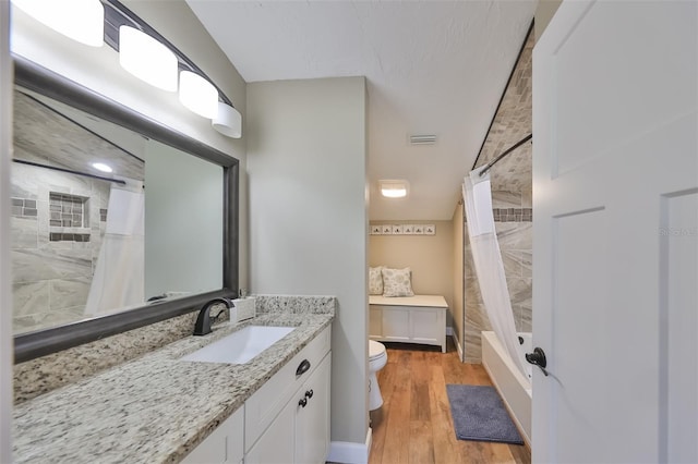 full bathroom with vanity, hardwood / wood-style floors, toilet, and shower / tub combo with curtain