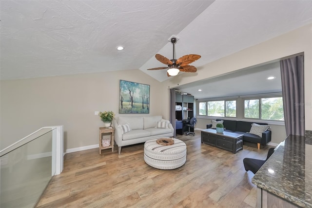 living room with hardwood / wood-style floors, vaulted ceiling, a textured ceiling, and ceiling fan