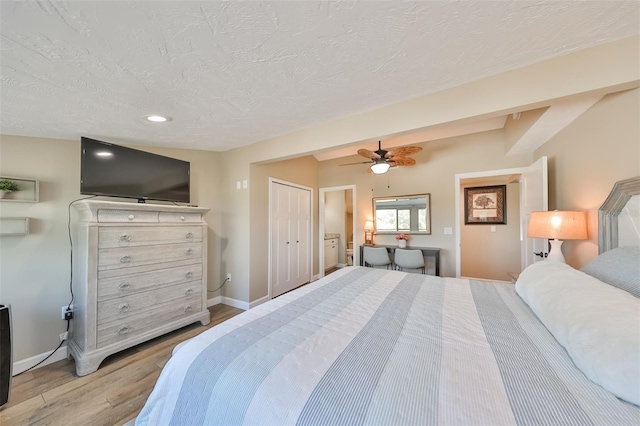 bedroom featuring a closet, a textured ceiling, ceiling fan, and light hardwood / wood-style flooring