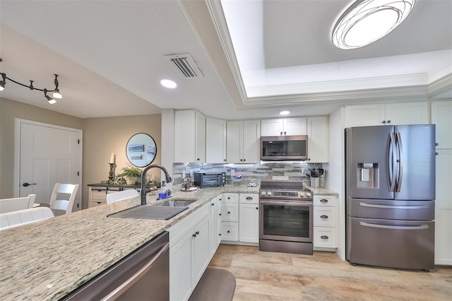 kitchen featuring stainless steel appliances, sink, and white cabinets