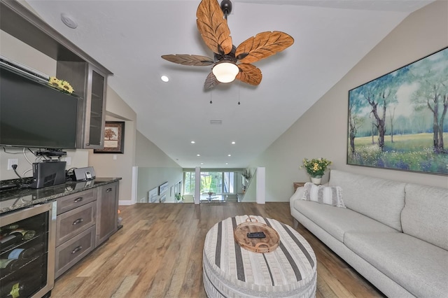 living room featuring light hardwood / wood-style flooring, vaulted ceiling, beverage cooler, and ceiling fan