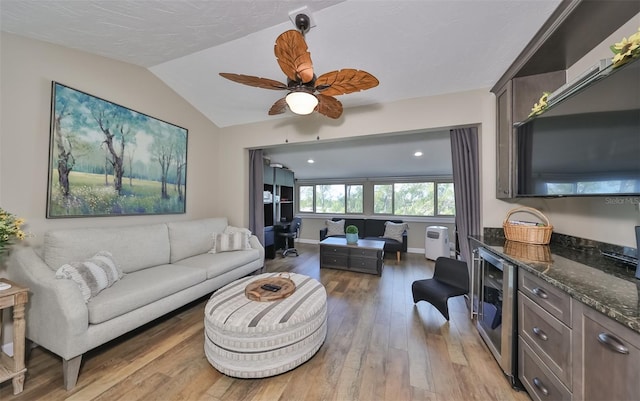 living room featuring wood-type flooring, lofted ceiling, wine cooler, and ceiling fan