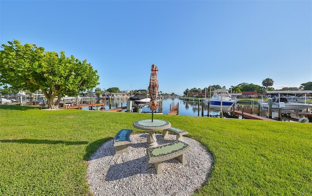 view of yard with a water view and a dock