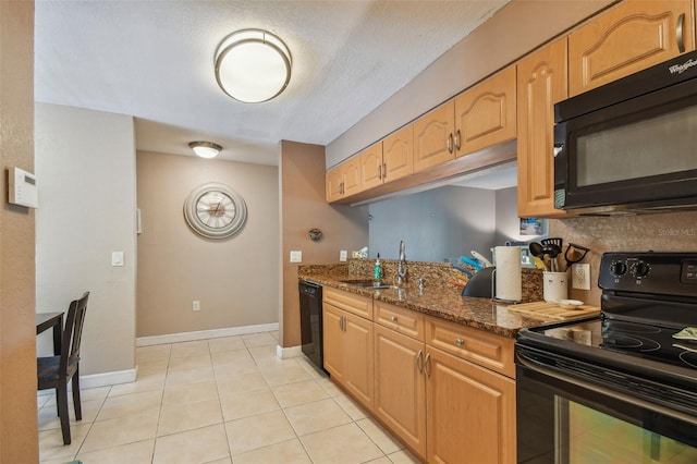 kitchen with light tile patterned flooring, sink, dark stone counters, and black appliances