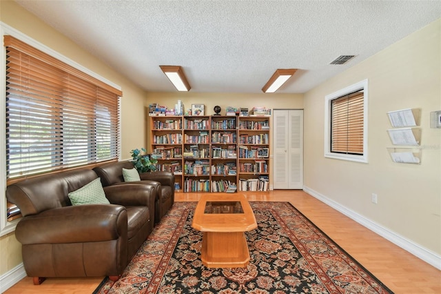 living area featuring wood-type flooring and a textured ceiling