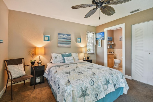 carpeted bedroom with ceiling fan, a closet, and ensuite bath