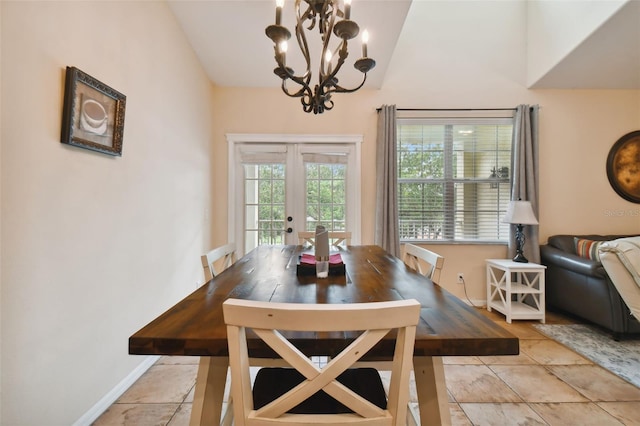 dining area with french doors, lofted ceiling, and a notable chandelier