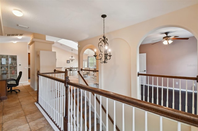 hallway featuring vaulted ceiling and an inviting chandelier