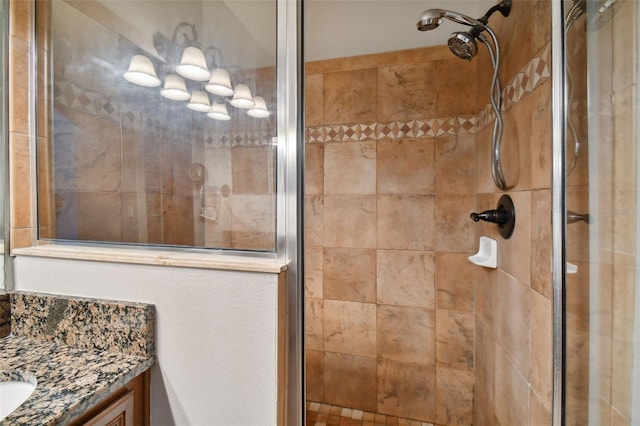 bathroom featuring a tile shower and vanity