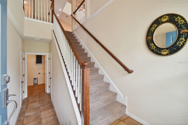 staircase featuring a high ceiling