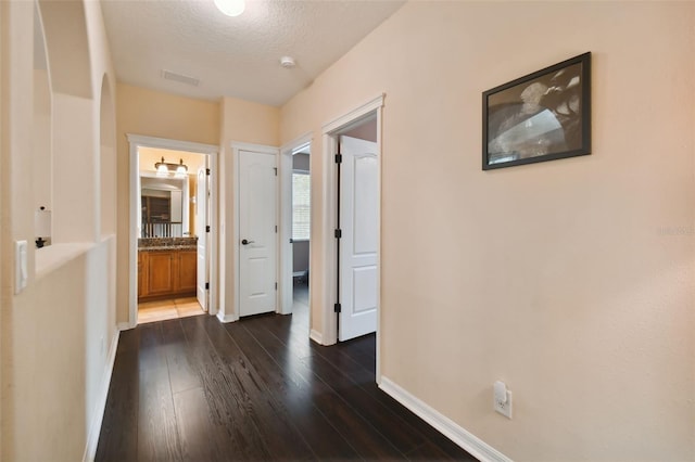 hallway featuring dark hardwood / wood-style flooring and a textured ceiling