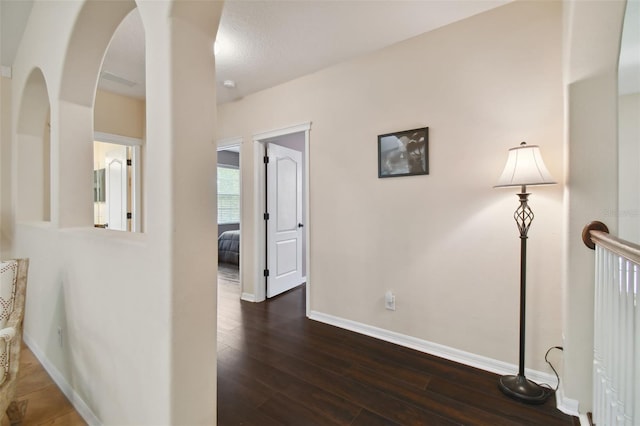 corridor featuring a textured ceiling and dark hardwood / wood-style floors