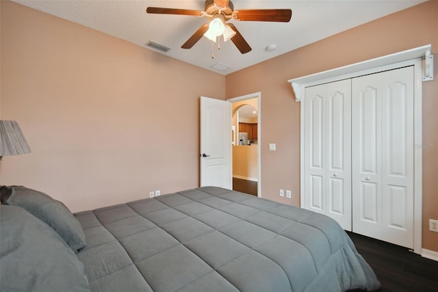 bedroom with dark hardwood / wood-style flooring, a closet, and ceiling fan