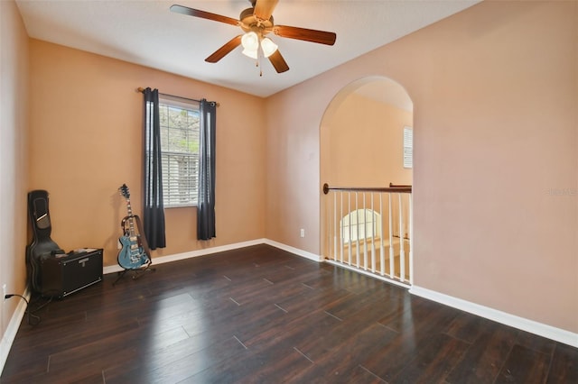 unfurnished room with ceiling fan and dark wood-type flooring