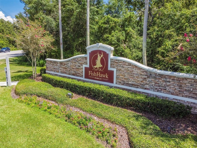 community / neighborhood sign featuring a lawn