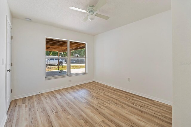 unfurnished room with ceiling fan, light hardwood / wood-style floors, and a textured ceiling