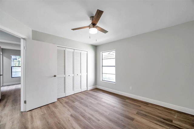 unfurnished bedroom with ceiling fan, a closet, and light hardwood / wood-style flooring