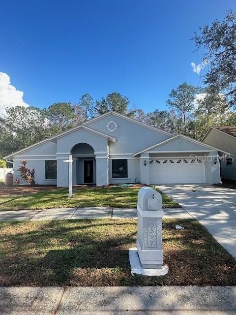 single story home with a front yard and a garage