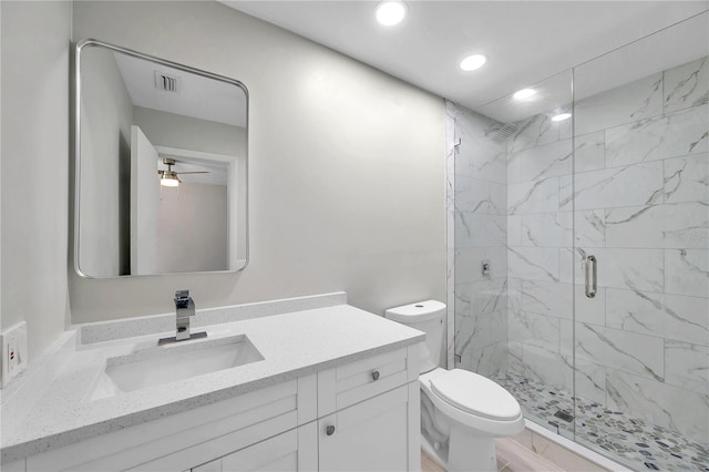 bathroom featuring vanity, a shower with shower door, and toilet