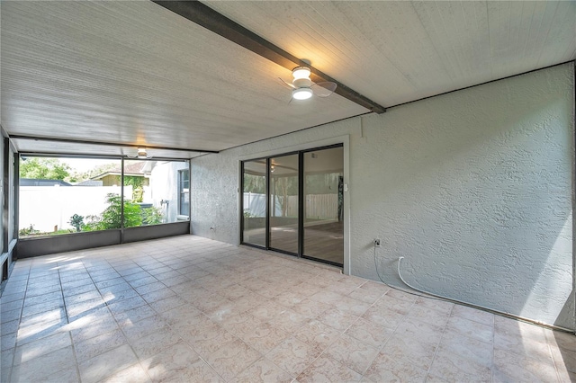 unfurnished sunroom featuring beam ceiling