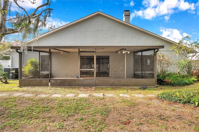 back of property with cooling unit, a yard, and a sunroom