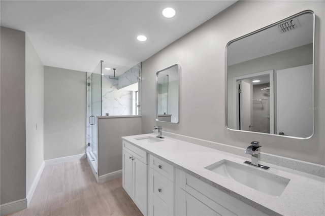 bathroom featuring wood-type flooring, vanity, and walk in shower